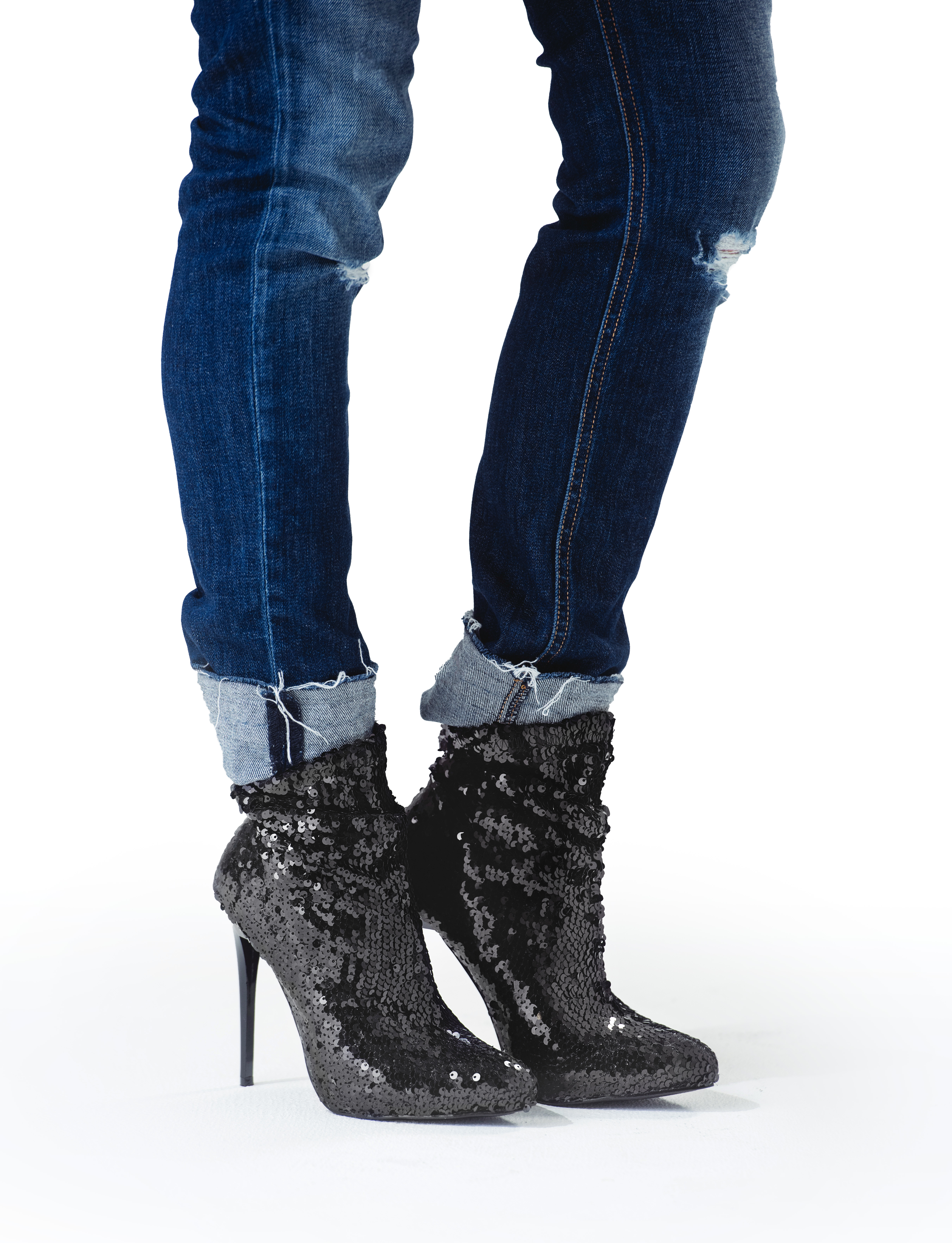 A pair of black boots and jeans on the legs