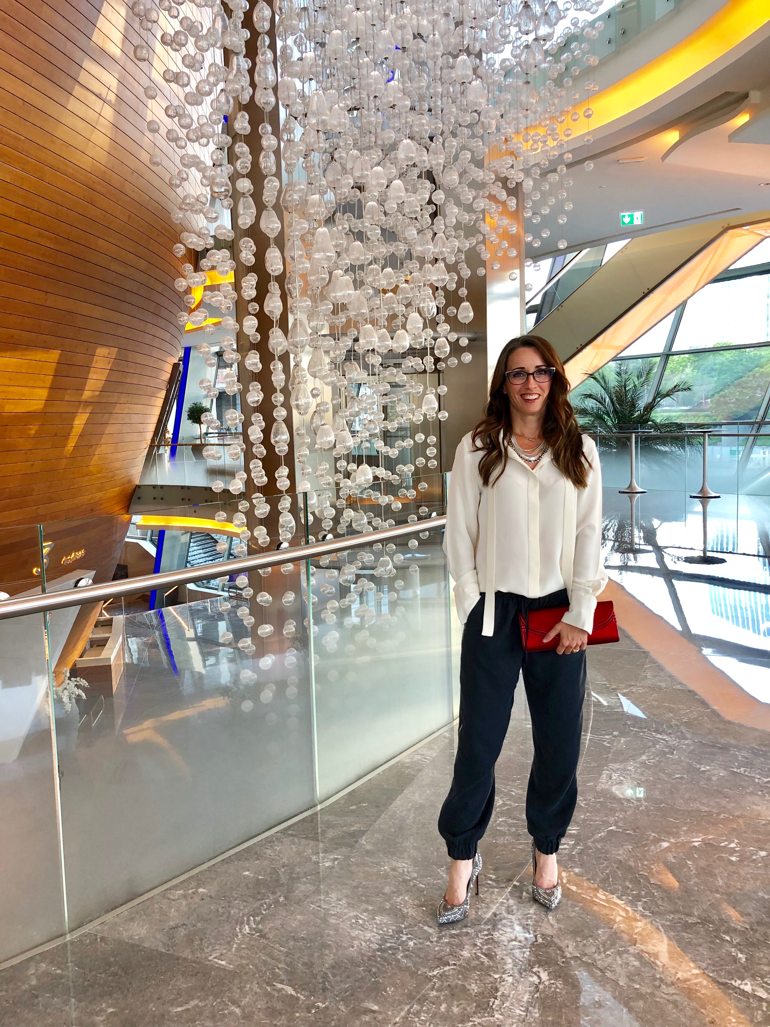 A woman standing in front of a glass wall.