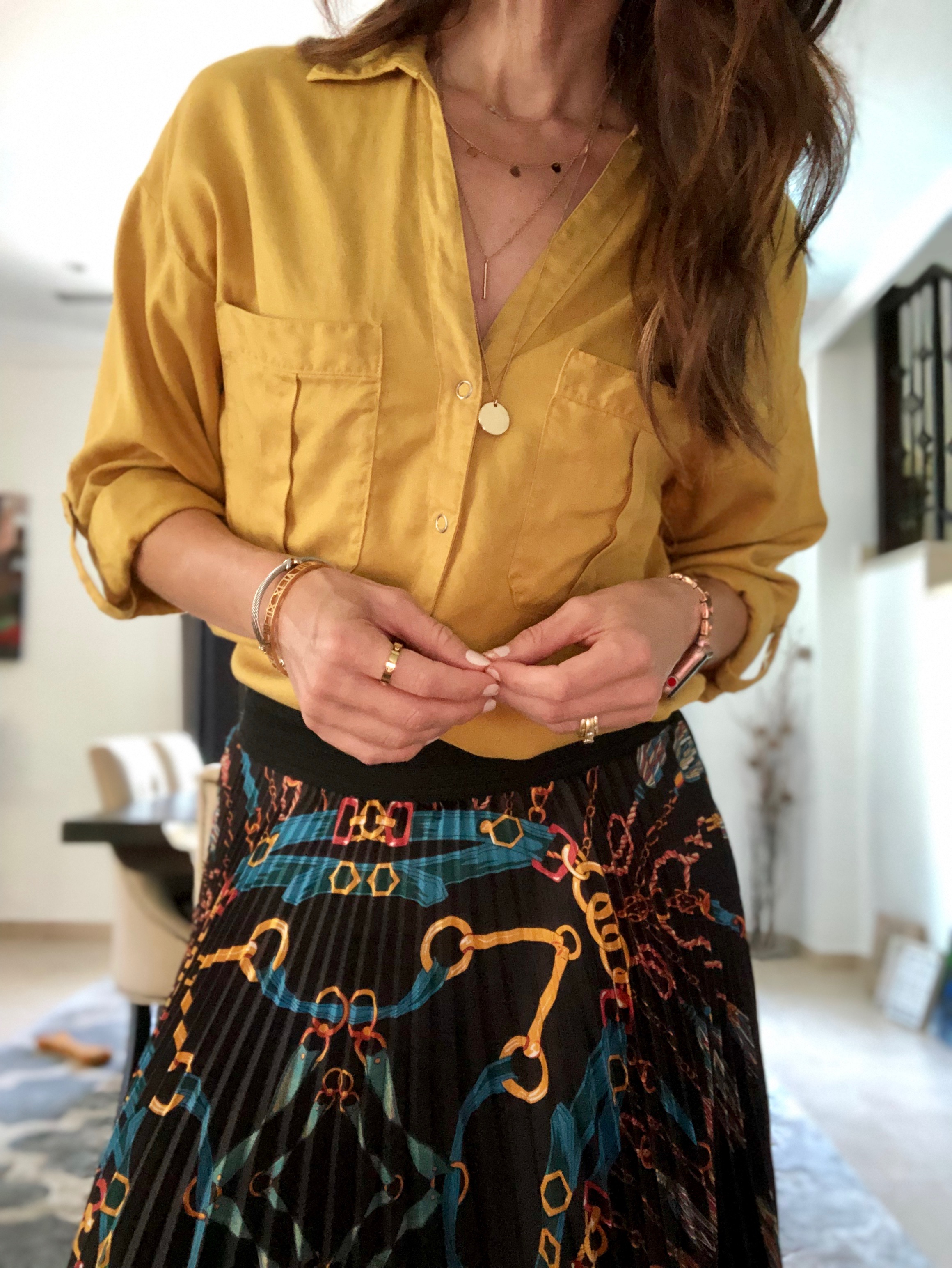 A woman in yellow shirt and black skirt.