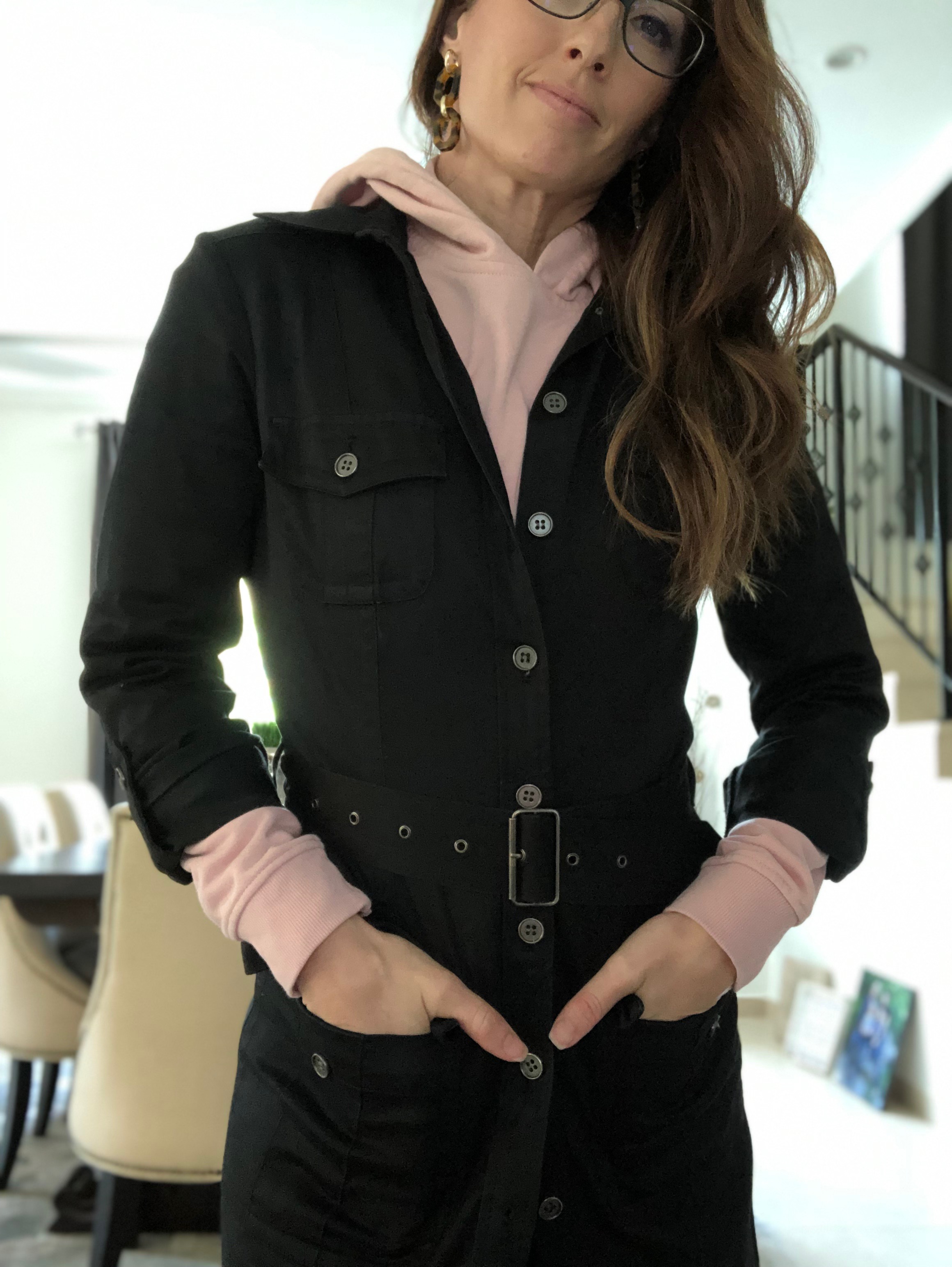 A woman in black jacket and pink shirt.