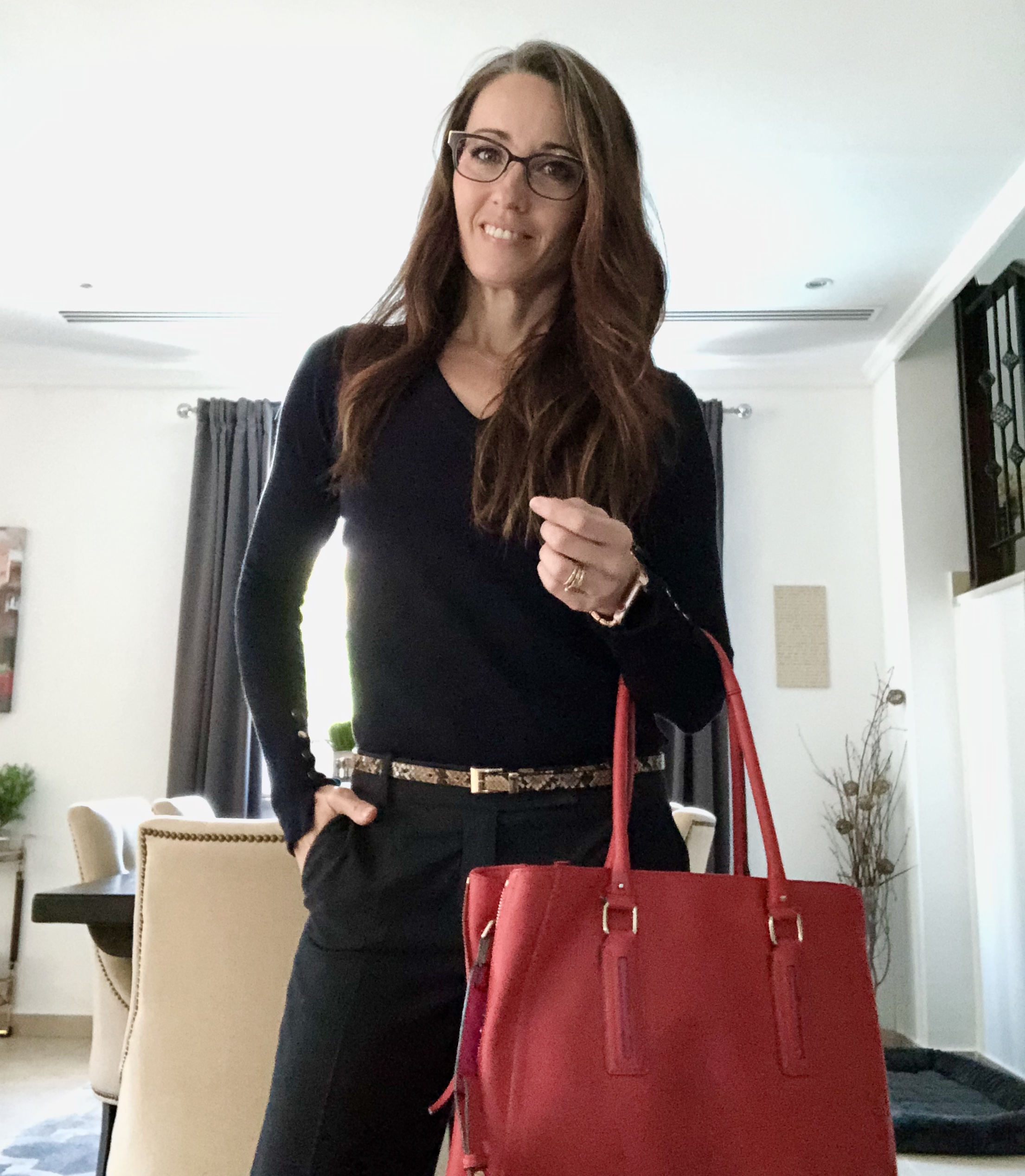 A woman holding onto her purse and smiling.