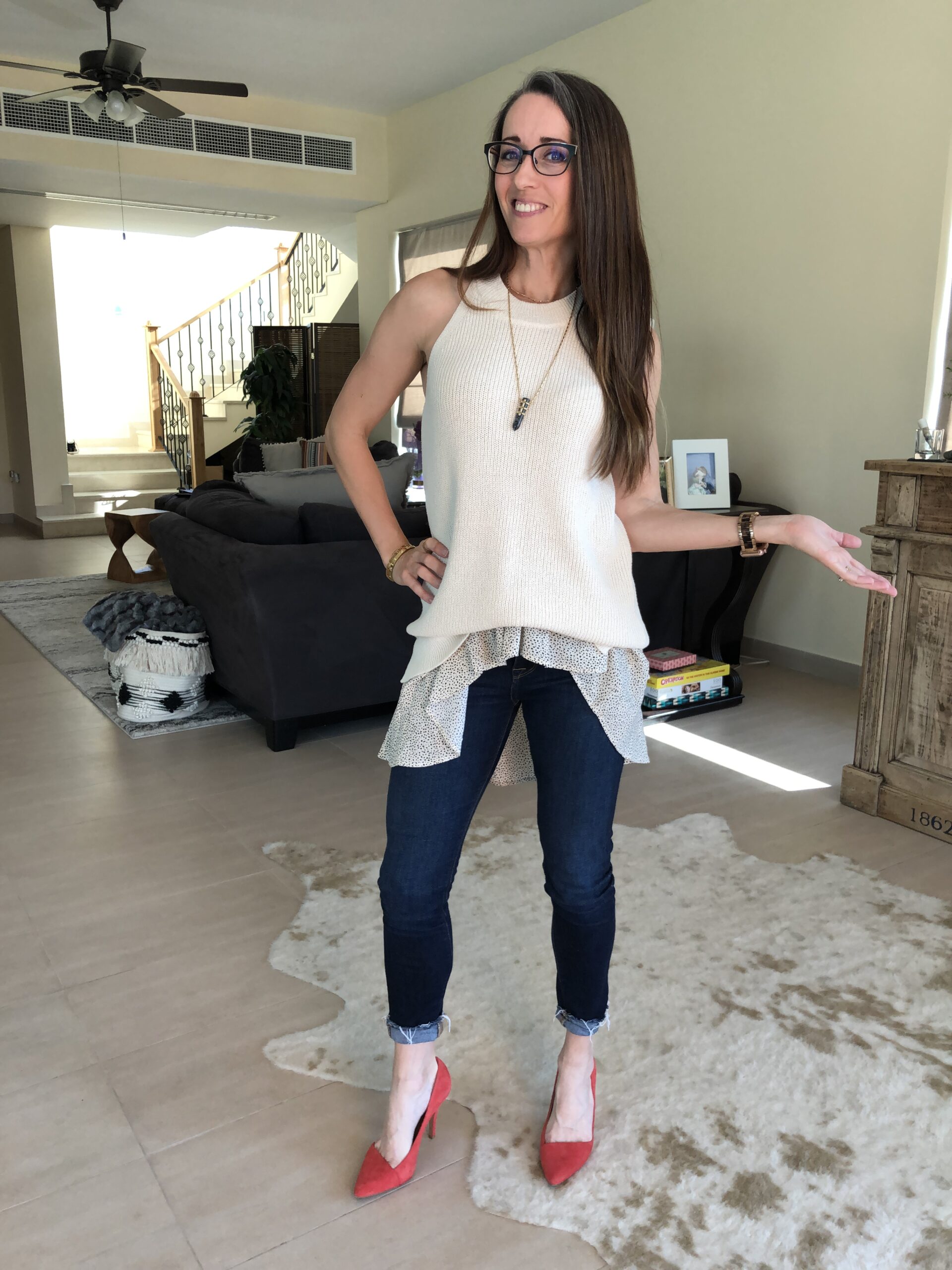 A woman standing in front of a living room.