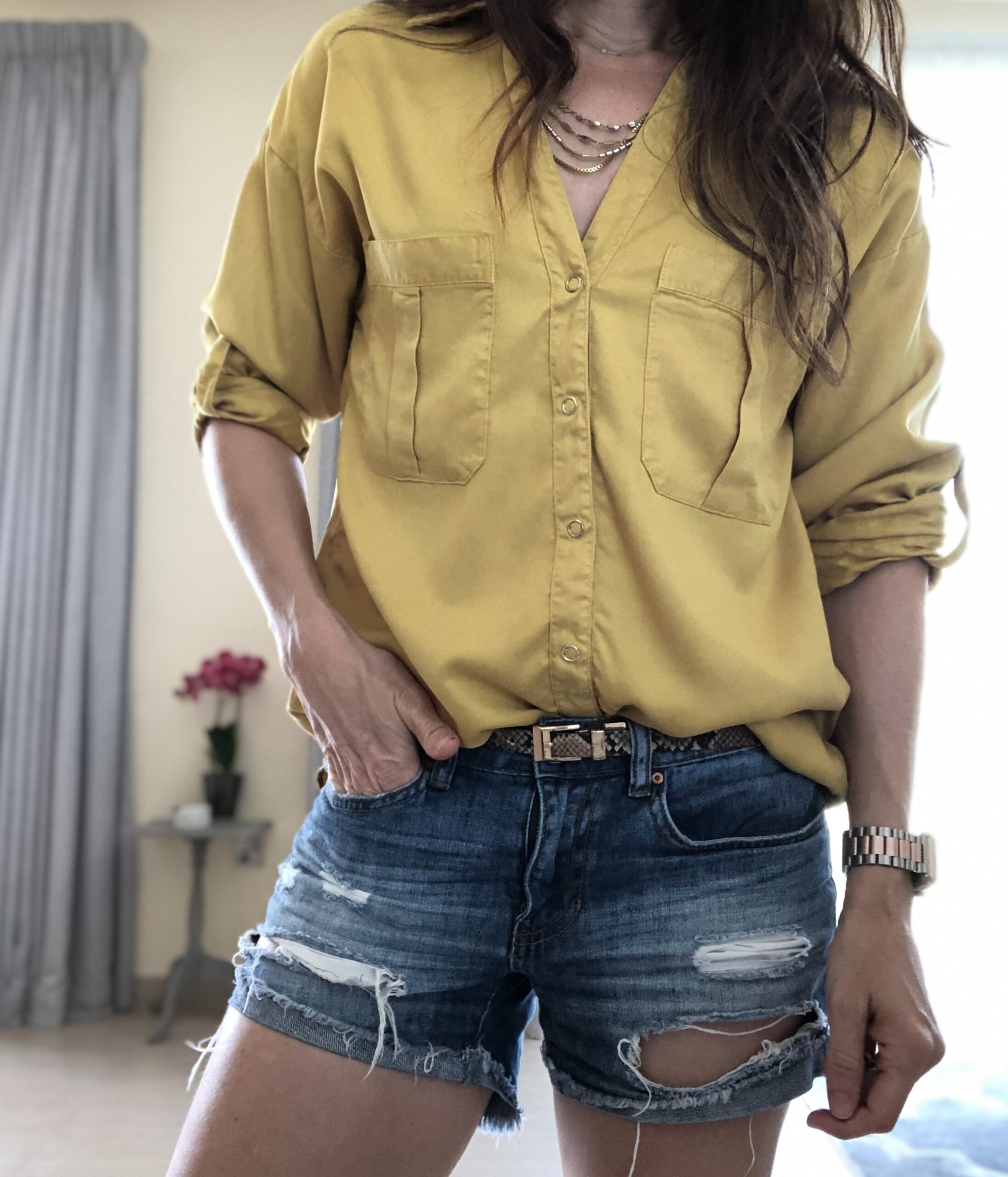 A woman wearing yellow shirt and blue shorts.