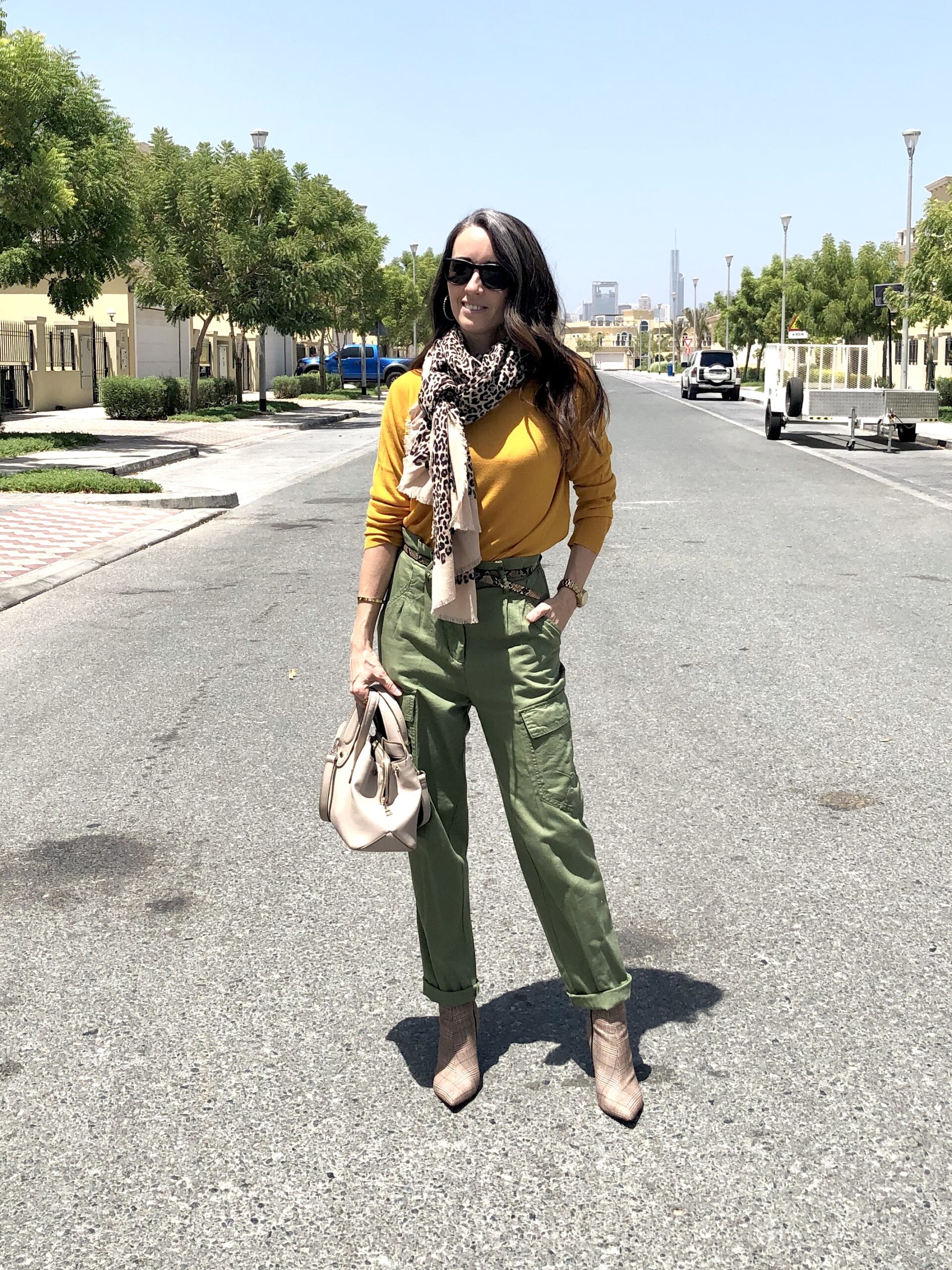 A woman standing on the side of a road.