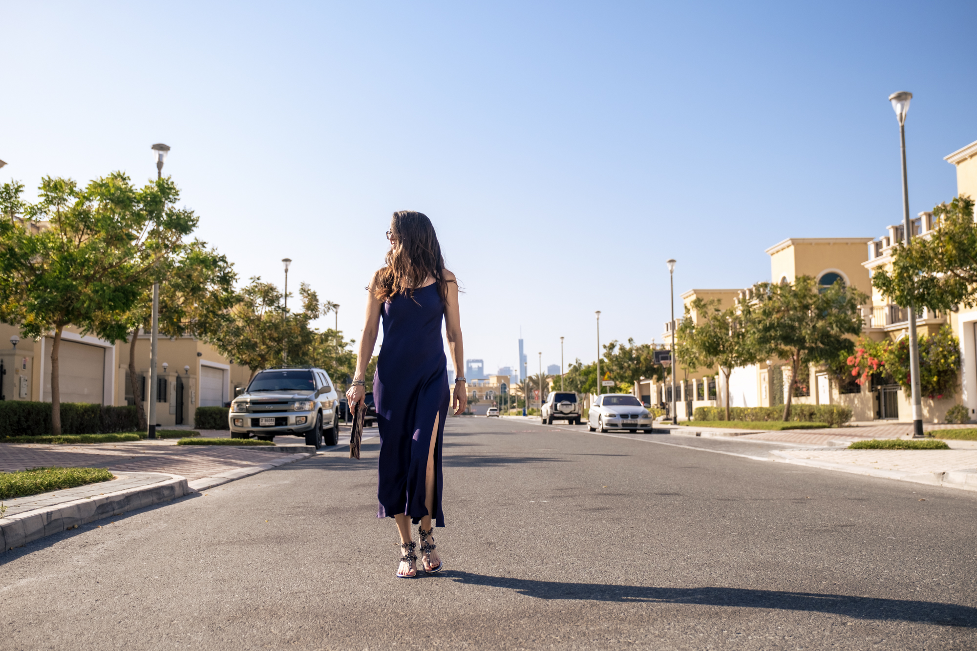 A woman is walking down the street in her dress.